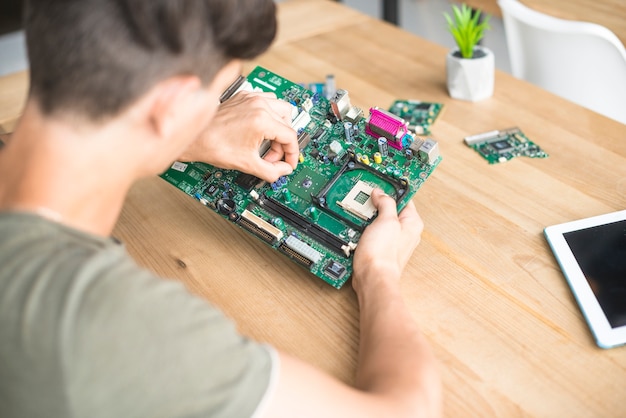 Visão aérea do homem consertando equipamentos de hardware de computador