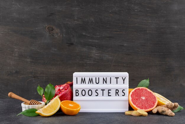 Visão frontal de alimentos que aumentam a imunidade com frutas cítricas e gengibre