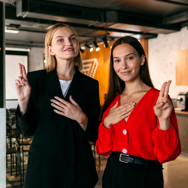 Foto grátis visão frontal de mulheres no trabalho usando a linguagem de sinais para se comunicar