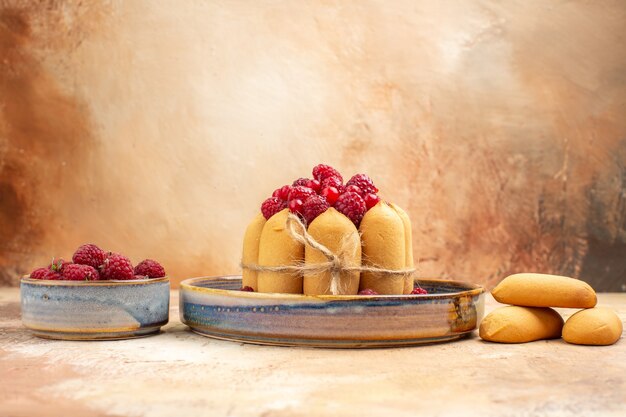 Visão horizontal de bolo macio recém-assado com frutas e biscoitos na mesa de cores diferentes