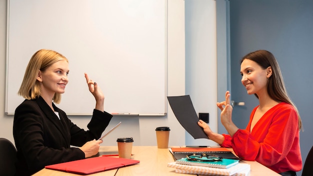 Foto grátis visão lateral de mulheres de negócios usando linguagem de sinais