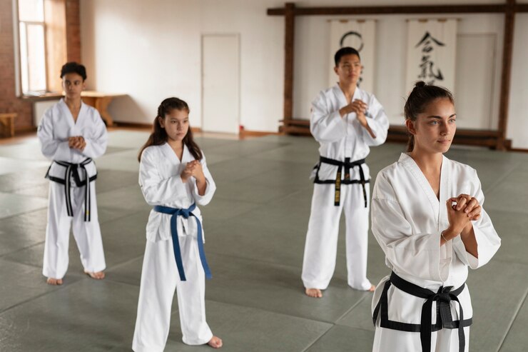 Foto grátis visão lateral de pessoas asiáticas a praticar taekwondo
