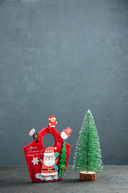 Visão remota do clima de natal com acessórios de decoração na caixa de presente de ano novo e árvore de natal na superfície escura