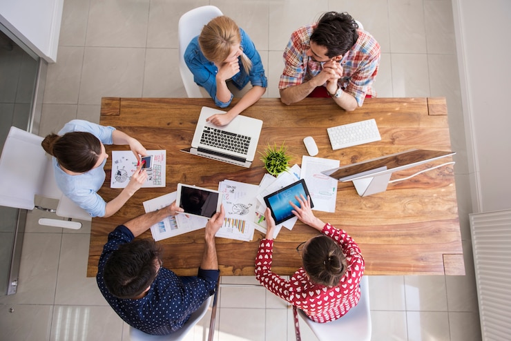 Foto grátis visão superior da equipe de colegas de trabalho trabalhando no escritório