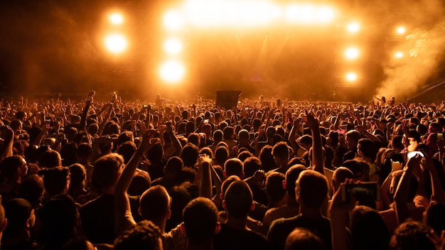 Visão traseira da multidão de fãs assistindo performance ao vivo no concerto de música à noite Copiar espaço