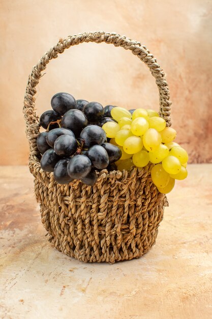 Visão vertical de cachos de uvas amarelas e pretas em uma cesta