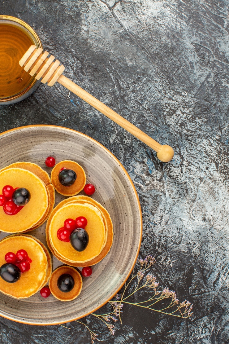 Foto grátis visão vertical de deliciosas panquecas de frutas e mel