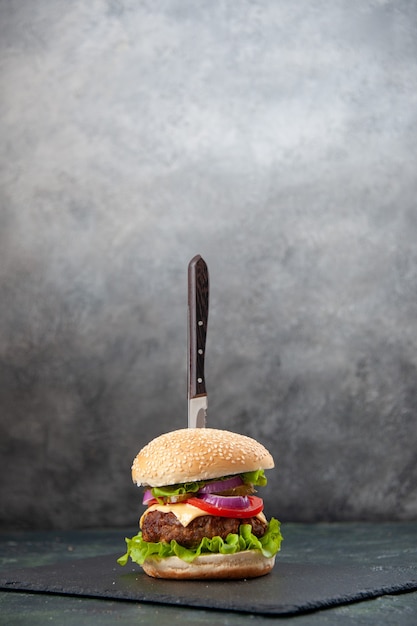 Foto grátis visão vertical de faca em um delicioso sanduíche na bandeja preta na superfície cinza turva isolada