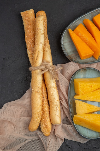 Visão vertical de fatias de queijo saboroso em uma toalha em um fundo preto