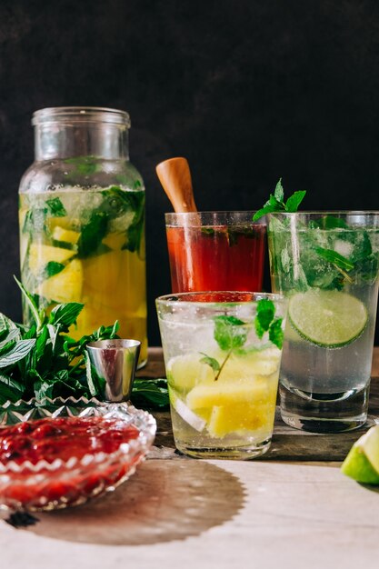 Visão vertical de refrigerantes feitos na hora com frutas e hortelã na mesa