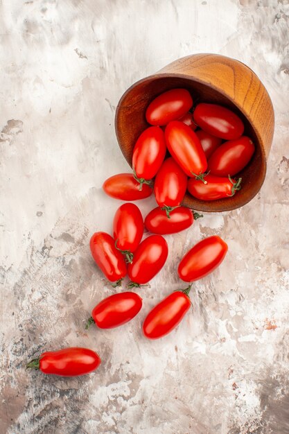 Visão vertical de tomates frescos caídos de uma pequena panela