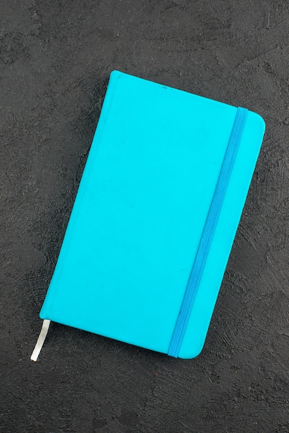 Visão vertical do caderno azul fechado em preto