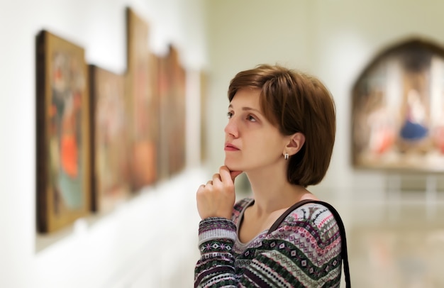Visitante que olha imagens na galeria de arte