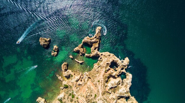 Vista aérea da cênica Ponta da Piedade de Lagos, Portugal. Falésias íngremes à beira-mar e águas do oceano azul na região do Algarve em Portugal