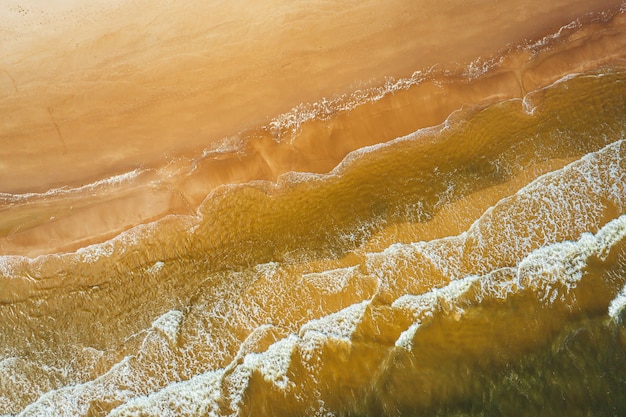 Vista aérea da onda do mar atingindo a costa