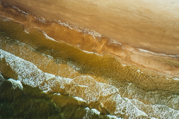 Vista aérea da onda do mar atingindo a costa