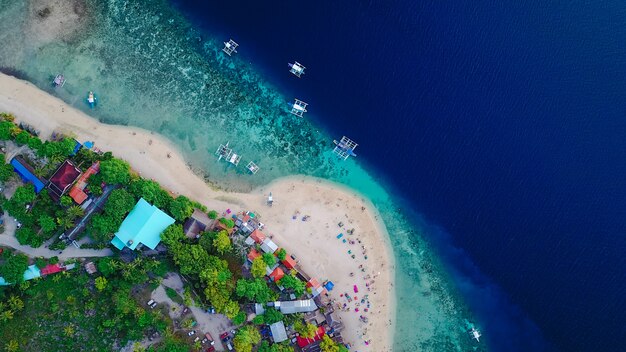 Vista aérea da praia arenosa com turistas que nadam na linda água do mar clara da ilha de Sumilon, pousando na praia perto de Oslob, Cebu, Filipinas. - Aumentar o processamento de cores.