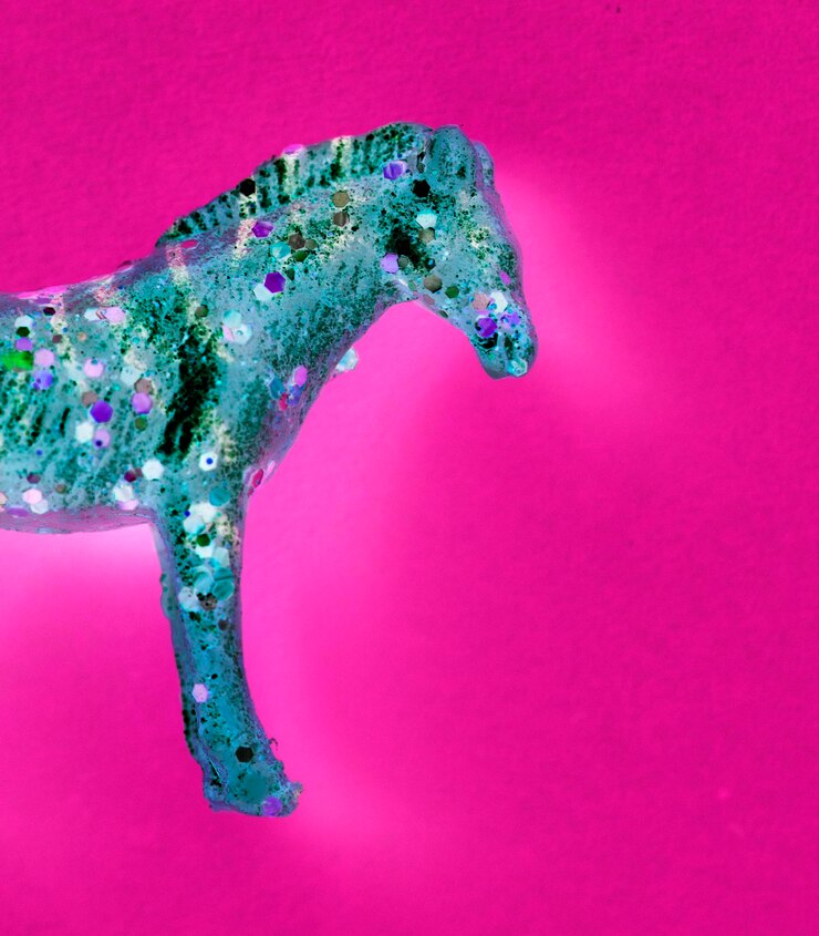 Foto grátis vista aérea de brinquedo de estatueta de cavalo com efeitos negativos em um fundo colorido