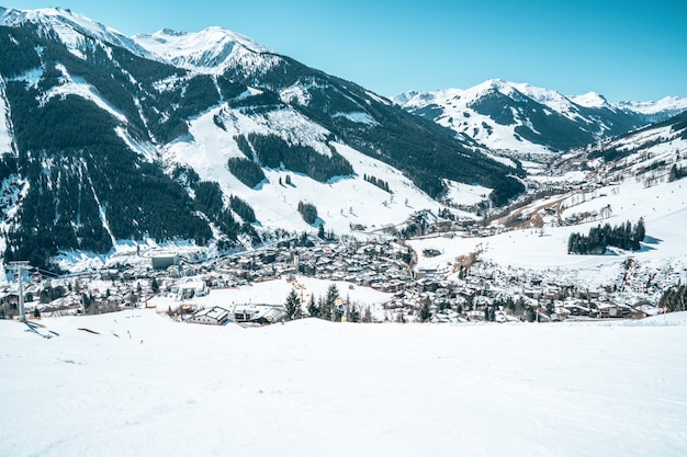 Vista aérea de uma cidade turística na Áustria cercada por montanhas nevadas