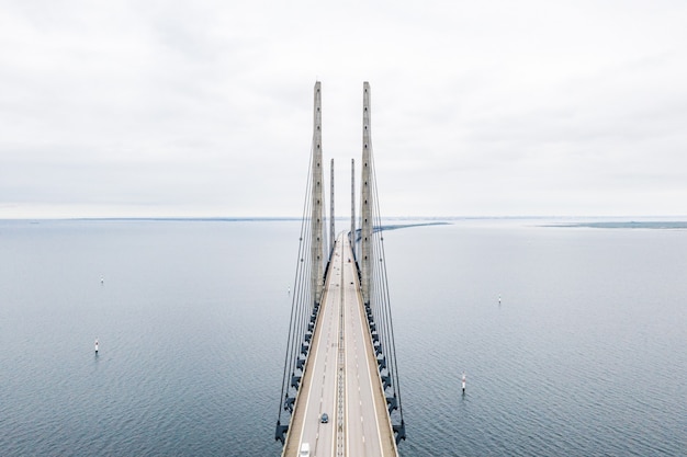 Vista aérea de uma ponte suspensa auto-ancorada em um mar azul