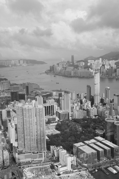 Vista aérea de Victoria Harbour e skyline em Hong Kong com arranha-céus urbanos em preto e branco.