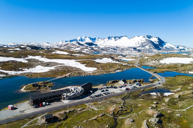 Vista aérea do centro de esqui à beira do lago cercado por uma paisagem montanhosa acidentada na Noruega
