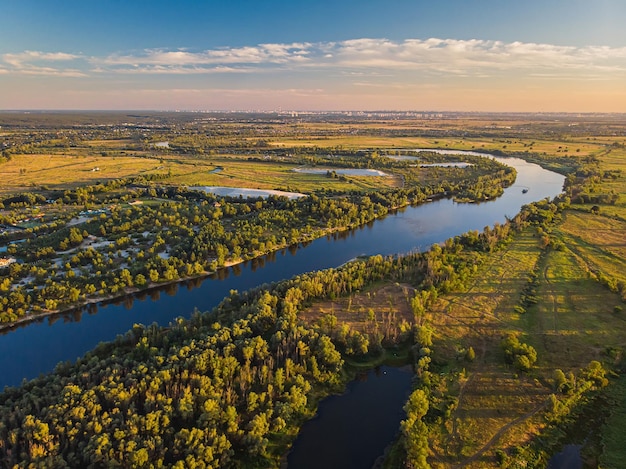 Vista aérea do drone A curva de um rio largo entre prados verdes