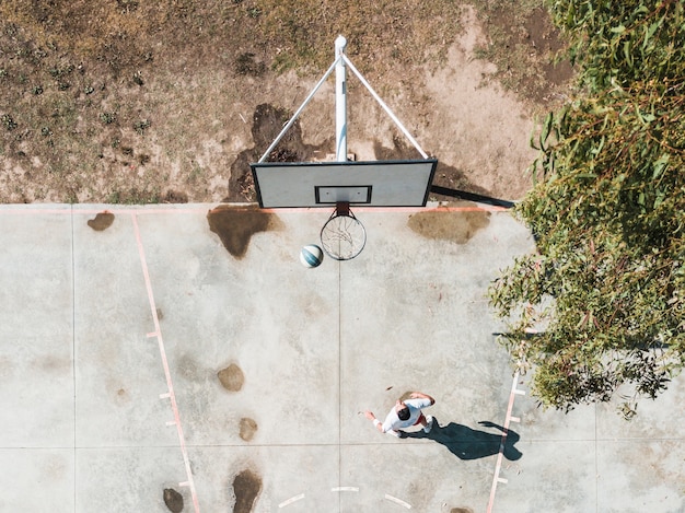 Vista alta ângulo, de, jogador, basquetebol jogando, em, a, aro