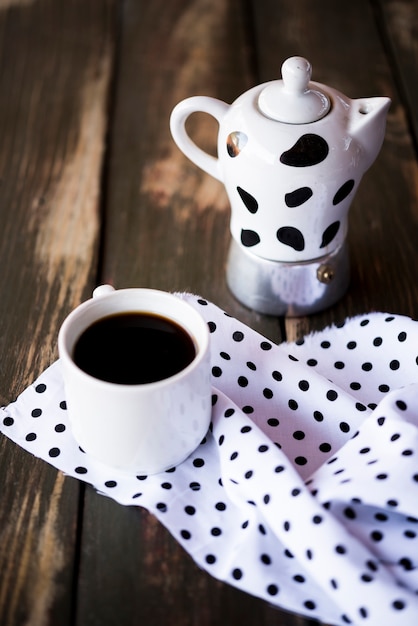 Vista alta bonito tecido pontilhado e chaleira com café