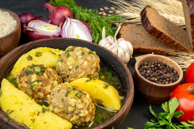 Vista aproximada da saborosa refeição de almôndega cebolas verdes alhos pimenta pão fatias de arroz em fundo preto