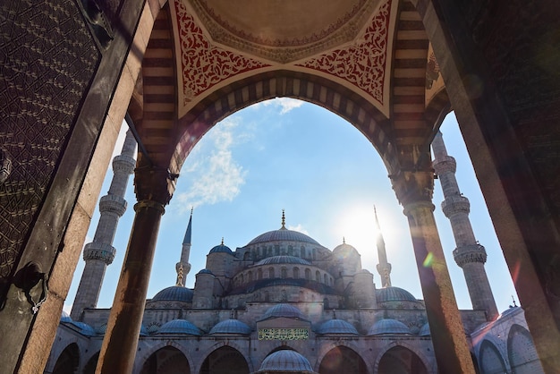 Vista através do arco e do portão para a mesquita azul Istambul é a Turquia