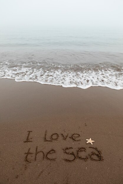 Vista da areia da praia no verão com uma mensagem escrita nela