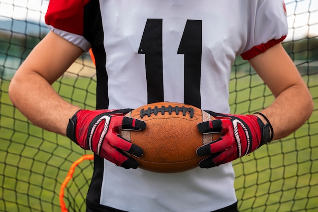 Foto grátis vista da bola de futebol americano nas mãos do jogador