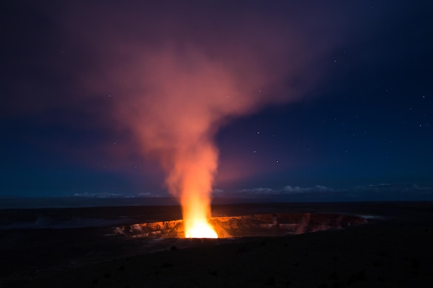 Vista da chama vinda do vulcão à noite