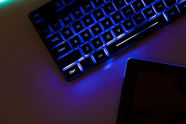 Foto grátis vista da configuração da mesa de jogos iluminada a néon com teclado