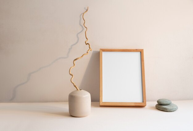 Vista da decoração do quarto composta de moldura e vaso de plantas com pedras