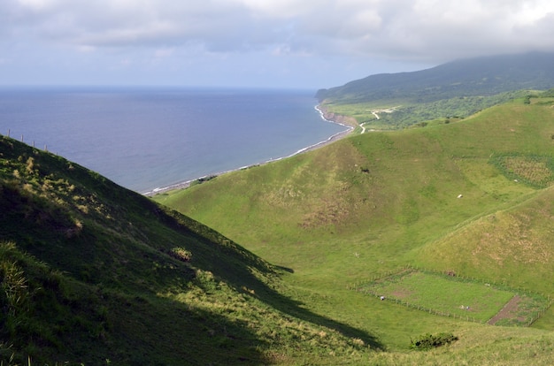 Vista da ilha coberta de vegetação ao redor de um mar de um ponto alto