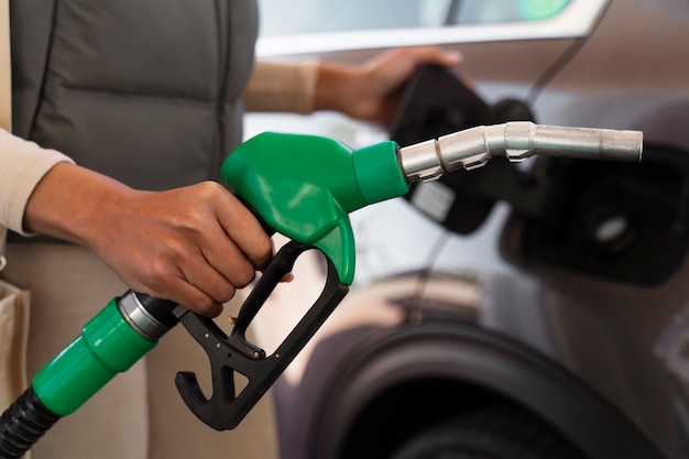 Vista da mulher com carro no posto de gasolina