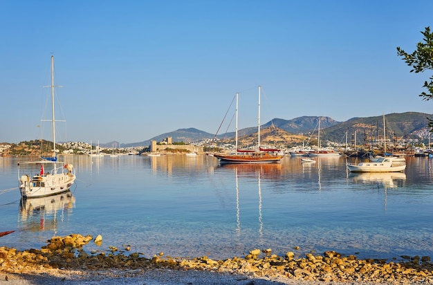 Vista da praia de Bodrum, mar Egeu, casas brancas tradicionais, flores, marina, barcos à vela