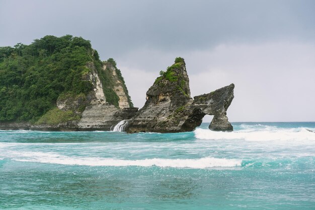 Vista da praia tropical, rochas do mar e oceano turquesa, céu azul. Praia de Atuh, ilha de Nusa Penida, Indonésia. Conceito de viagens. Indonésia