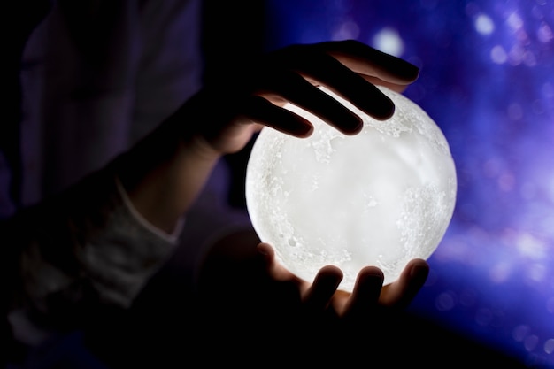 Vista das mãos segurando a luz da lua