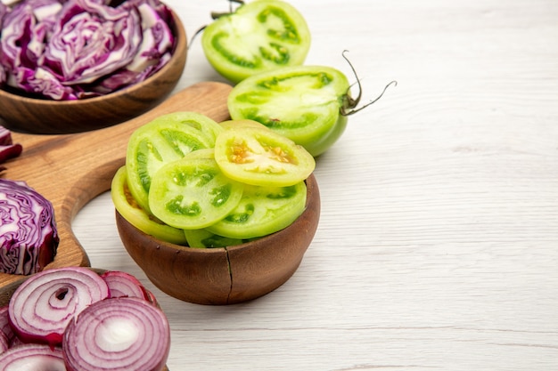 Foto grátis vista de baixo, repolho vermelho picado, cebola, tomate verde picado em tigelas na superfície branca