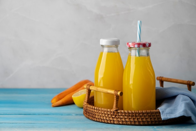 Foto grátis vista de bebidas cítricas e cenouras