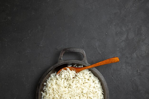 Vista de cima arroz cozido dentro da panela na mesa escura jantar refeição comida arroz oriental