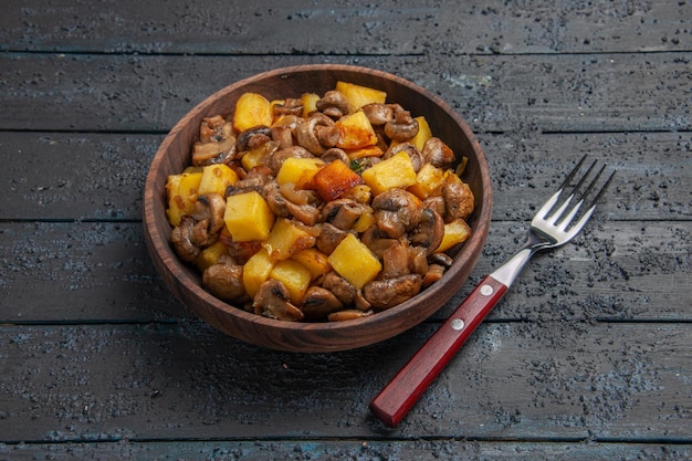 Foto grátis vista de cima batatas com prato de cogumelos com batatas e cogumelos e um garfo no centro da mesa cinza