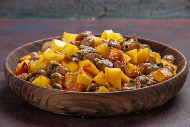 Vista de cima batatas com purê de cogumelos com batatas em uma tigela na superfície escura