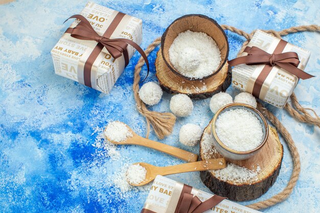 Vista de cima, bolas de coco, tigelas de corda com pó de coco no fundo branco azul