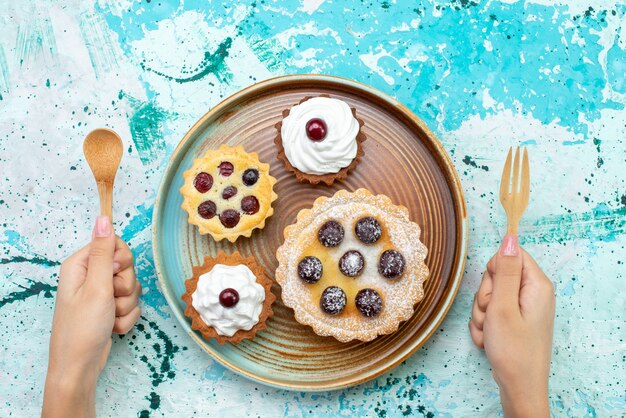 Vista de cima bolinhos com açúcar em pó creme de frutas no chá de frutas com creme