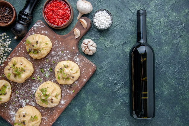 Foto grátis vista de cima bolinhos de massa crus com molho de tomate em fundo azul escuro cozinhando massa de jantar prato refeição cozinha carne vinho