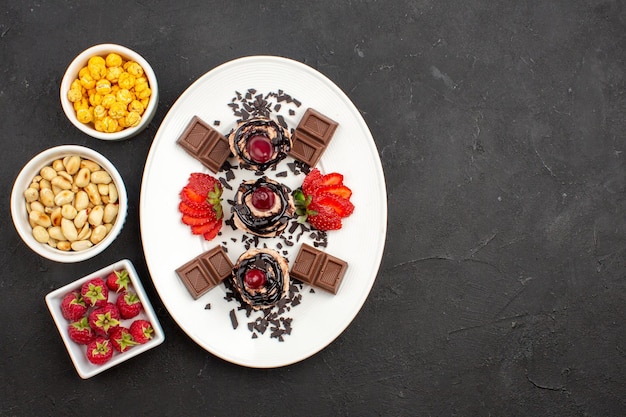 Foto grátis vista de cima bolinhos gostosos com barras de chocolate e nozes na superfície escura, nozes, bolo de frutas, torta, biscoito, baga